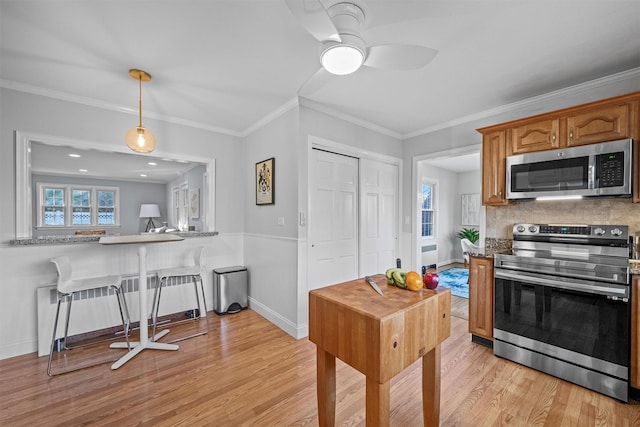 kitchen with stainless steel appliances, ornamental molding, backsplash, kitchen peninsula, and light wood-type flooring