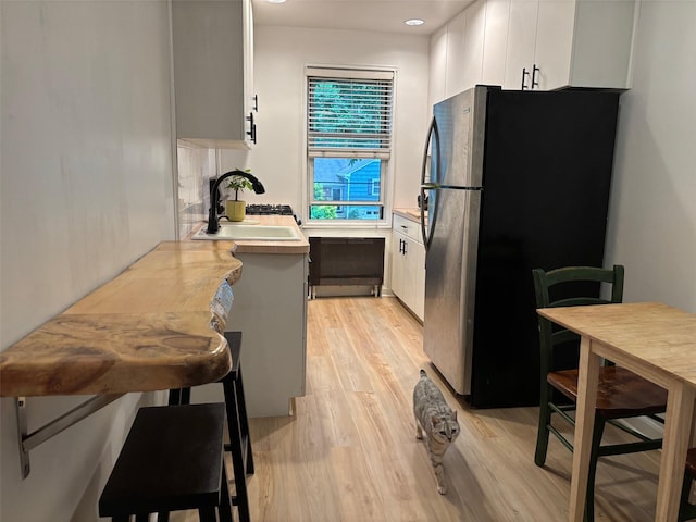 2295 Palmer Ave Unit 1P, New Rochelle, NY 10801 - kitchen featuring freestanding refrigerator, a sink, light wood-type flooring, light countertops, and white cabinets