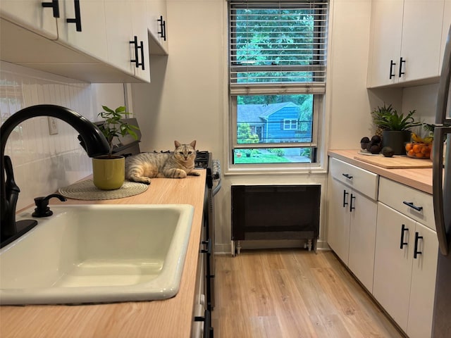 2295 Palmer Ave Unit 1P, New Rochelle, NY 10801 - kitchen featuring a sink, light countertops, white cabinets, and light wood-type flooring