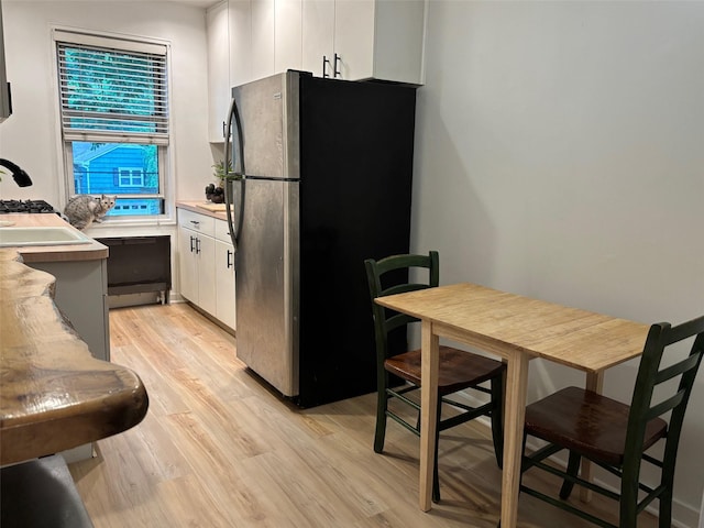 2295 Palmer Ave Unit 1P, New Rochelle, NY 10801 - kitchen featuring freestanding refrigerator, light wood-style flooring, white cabinetry, and light countertops