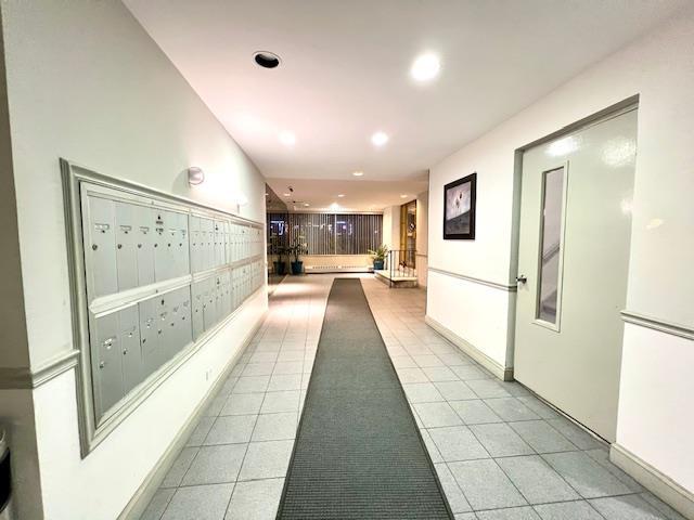 hallway with recessed lighting, mail area, baseboards, and light tile patterned flooring