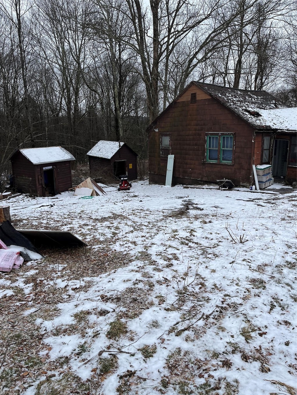 snowy yard with a storage shed