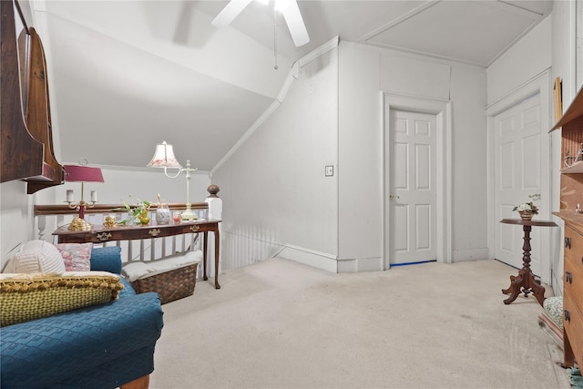 interior space featuring ceiling fan, light colored carpet, lofted ceiling, and ornamental molding