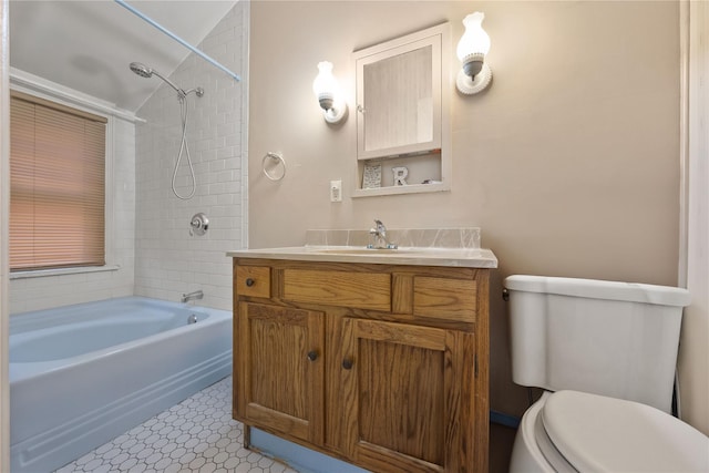 full bathroom featuring tile patterned floors, vanity, tiled shower / bath combo, and toilet