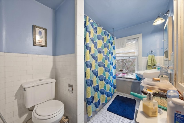 bathroom with tile patterned floors, a shower with curtain, toilet, and tile walls