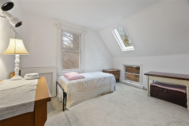 carpeted bedroom featuring lofted ceiling with skylight