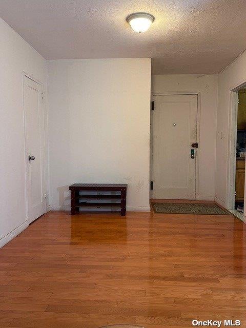 hall featuring light hardwood / wood-style floors and a textured ceiling