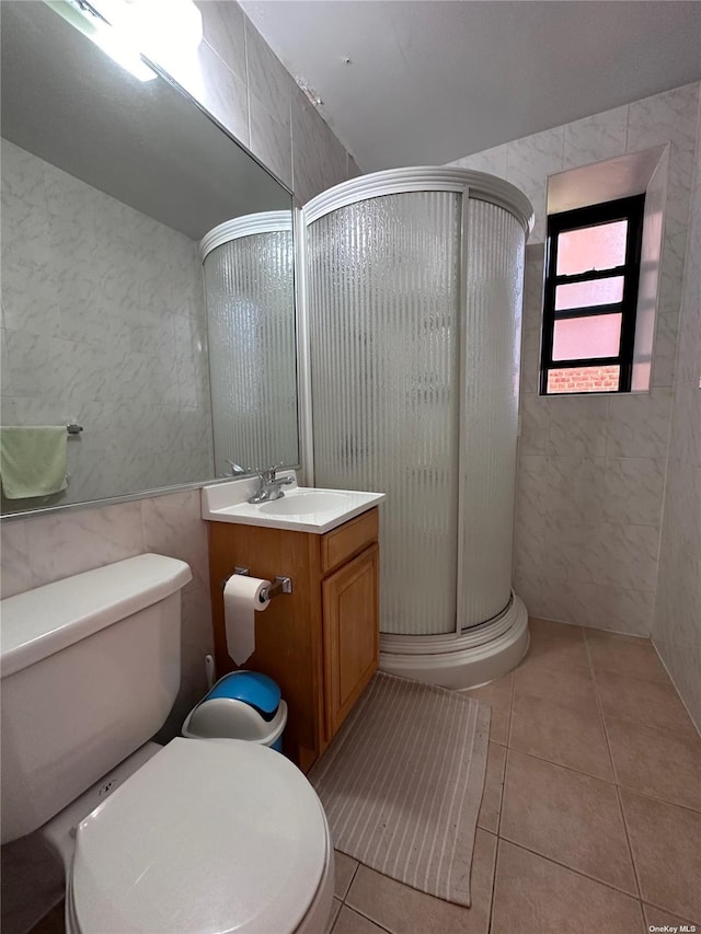 bathroom featuring walk in shower, vanity, tile walls, tile patterned flooring, and toilet