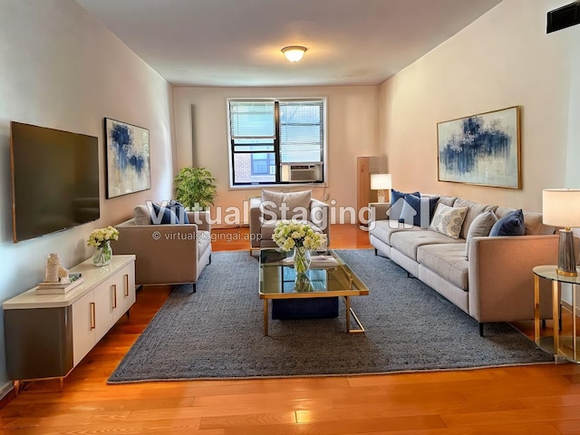 living area featuring visible vents, cooling unit, and wood finished floors