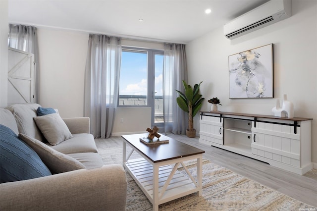 living room featuring a wall mounted air conditioner and light hardwood / wood-style flooring