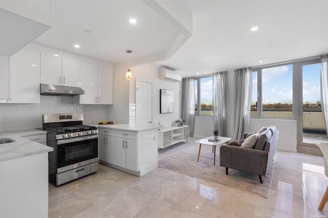 kitchen featuring kitchen peninsula, stainless steel range with gas cooktop, white cabinets, and pendant lighting