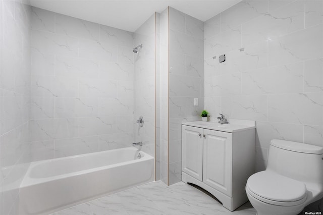 full bathroom with vanity, toilet, tiled shower / bath, and tile walls