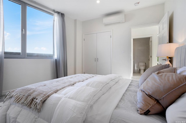 bedroom featuring a closet, an AC wall unit, and multiple windows