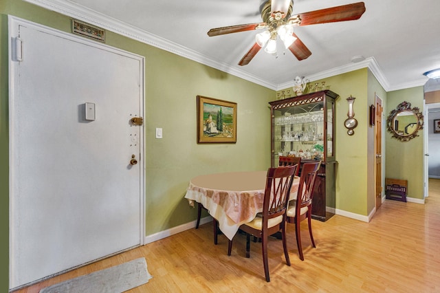 dining space featuring ceiling fan, light hardwood / wood-style flooring, and ornamental molding