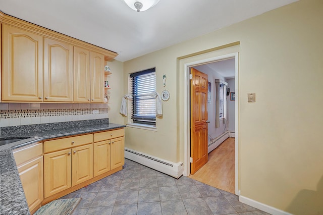 kitchen featuring tile patterned flooring, light brown cabinets, baseboard heating, and tasteful backsplash