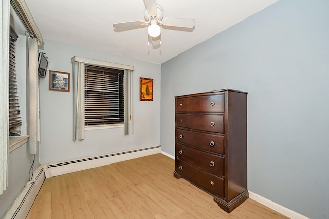 bedroom featuring light wood-type flooring, a baseboard radiator, and ceiling fan