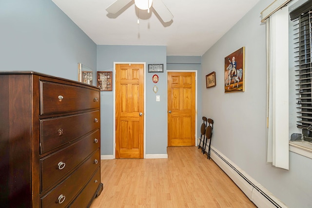 bedroom featuring baseboard heating, ceiling fan, and light hardwood / wood-style flooring