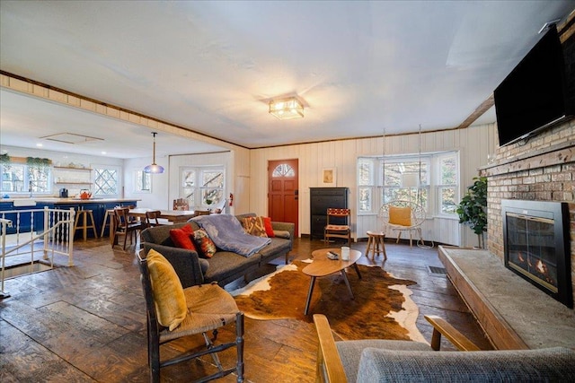 living room featuring ornamental molding, a fireplace, and dark wood-type flooring