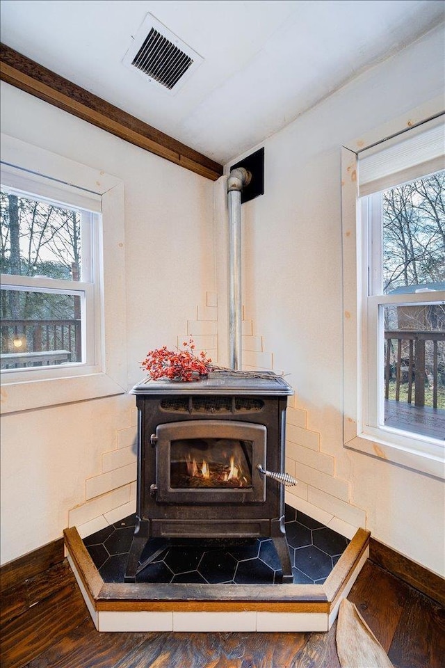 interior details with a wood stove and hardwood / wood-style flooring