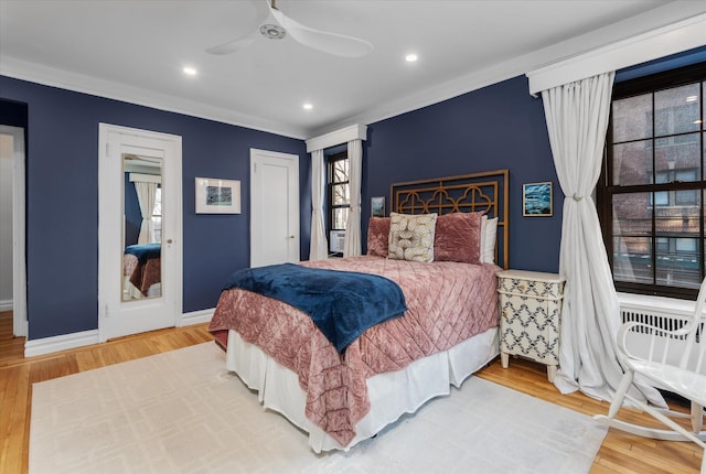 bedroom with wood-type flooring, ceiling fan, and crown molding