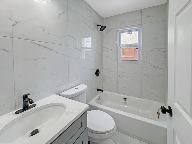 full bathroom with tiled shower / bath, tile walls, vanity, and toilet