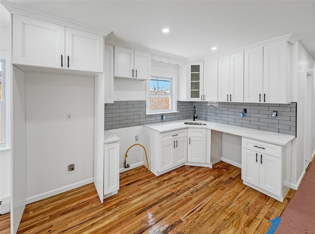 kitchen featuring light wood-type flooring, sink, and white cabinets