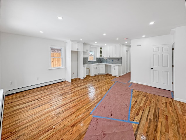 unfurnished living room with light hardwood / wood-style flooring and baseboard heating