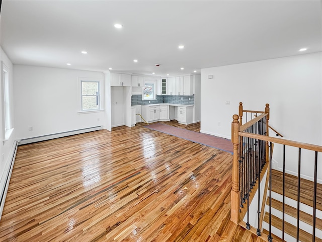 living room featuring baseboard heating and light hardwood / wood-style flooring