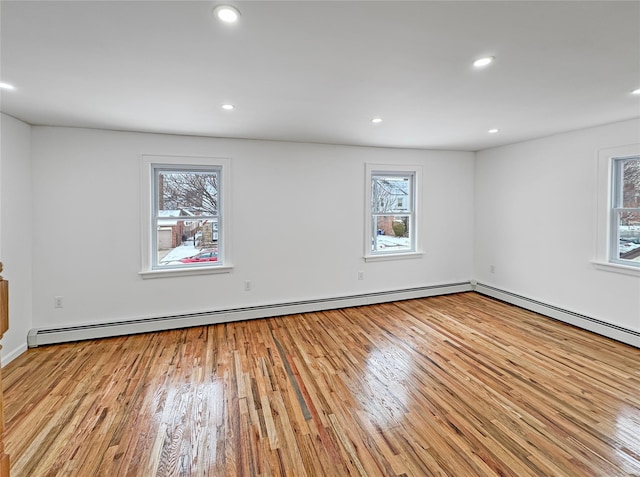 spare room featuring plenty of natural light, light wood-type flooring, and baseboard heating