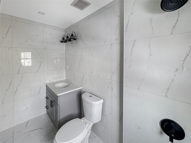 bathroom featuring vanity, tile walls, walk in shower, and toilet