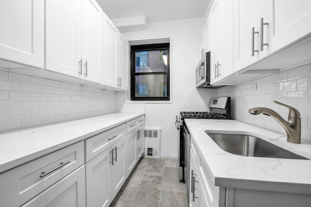 kitchen featuring light stone countertops, appliances with stainless steel finishes, and white cabinetry