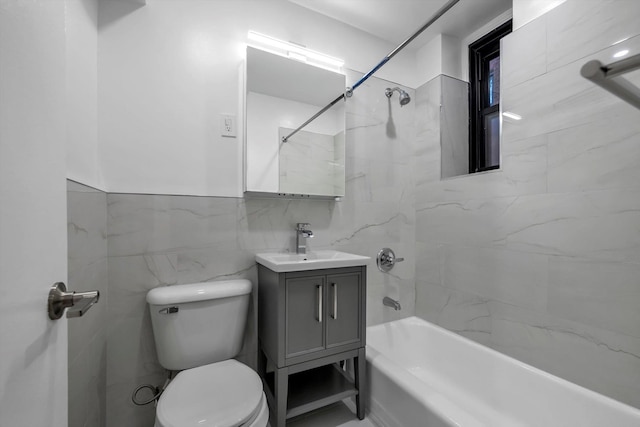 full bathroom featuring vanity, toilet, tile walls, and tiled shower / bath combo