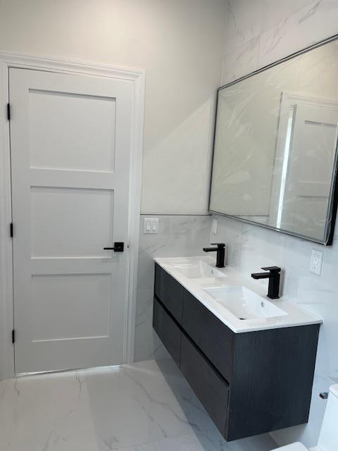 bathroom with backsplash, vanity, and tile walls