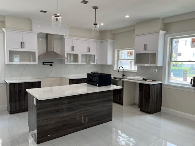 149 Revere Ave, Bronx, NY 10465 - kitchen with wall chimney range hood, baseboards, tasteful backsplash, and a kitchen island