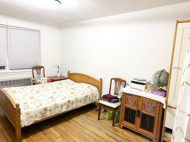 bedroom featuring light hardwood / wood-style flooring and radiator heating unit