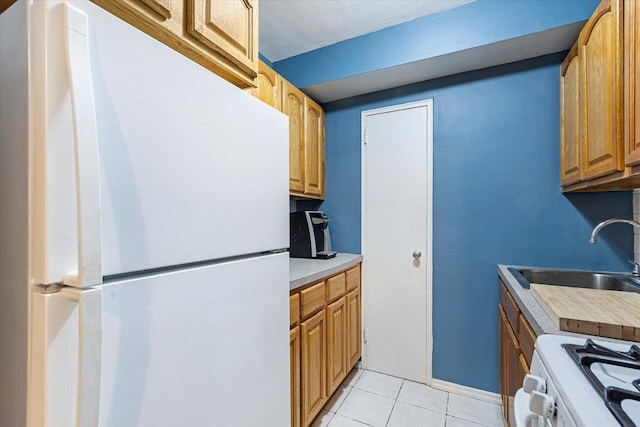 kitchen with light tile patterned flooring, white appliances, and sink