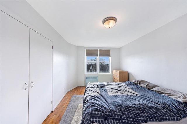 bedroom featuring radiator and light hardwood / wood-style flooring