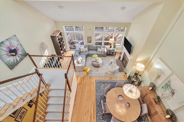 living room with a towering ceiling and wood-type flooring