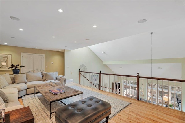 living room featuring lofted ceiling and light hardwood / wood-style flooring