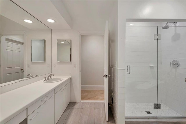 bathroom featuring vanity and a shower with door