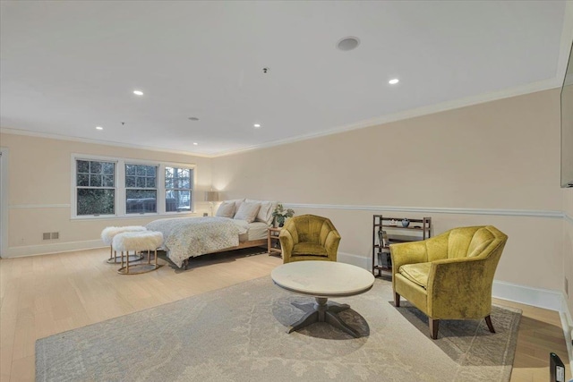 bedroom with ornamental molding and light hardwood / wood-style floors