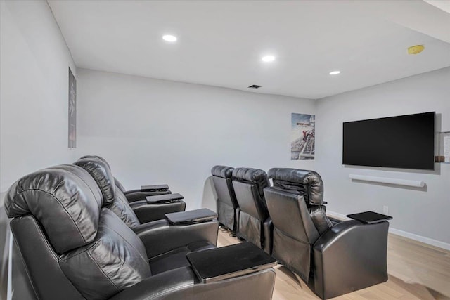 cinema room with light hardwood / wood-style floors