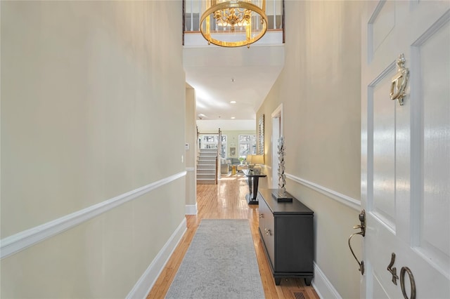 hall featuring a notable chandelier and light wood-type flooring