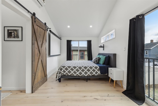 bedroom with a barn door, light wood-type flooring, and vaulted ceiling