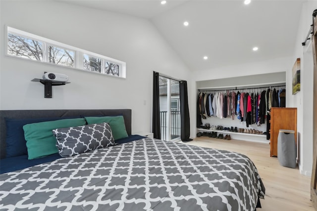 bedroom featuring a closet, high vaulted ceiling, and wood-type flooring