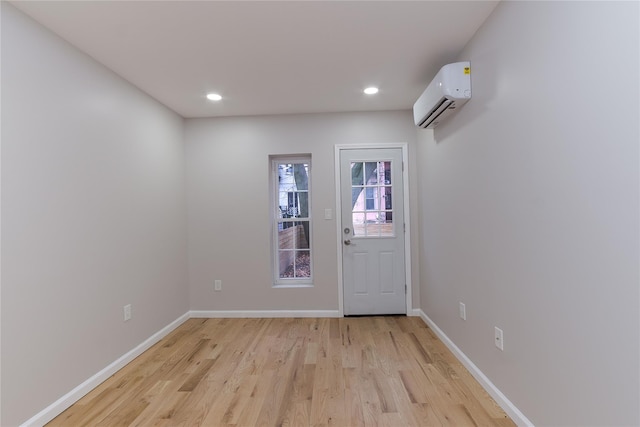 doorway featuring a wall mounted air conditioner and light hardwood / wood-style flooring