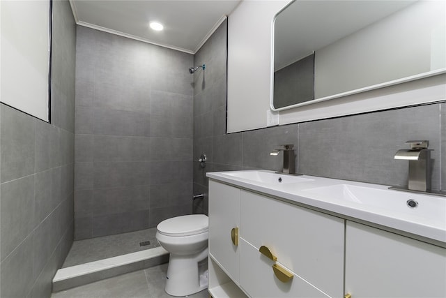 bathroom with vanity, toilet, tiled shower, tile walls, and tasteful backsplash