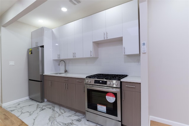 kitchen featuring white cabinets, sink, decorative backsplash, appliances with stainless steel finishes, and dark brown cabinetry