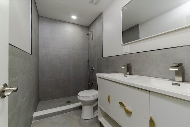 bathroom featuring backsplash, vanity, tiled shower, tile walls, and toilet