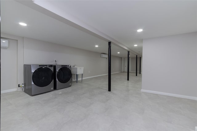 washroom featuring washing machine and dryer, an AC wall unit, and sink